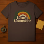 Brown t-shirt with vintage "Camp Counselor" text and rainbow graphic.