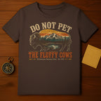 Brown t-shirt with a distressed graphic of a bison, mountains, and forest. Text reads "DO NOT PET THE FLUFFY COWS".