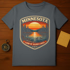 Dark grey t-shirt featuring a Minnesota Land of 10,000 Lakes sunset lake scene design.