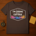 Brown t-shirt with "I'm Coming to the Cottage" and colorful forest graphic.