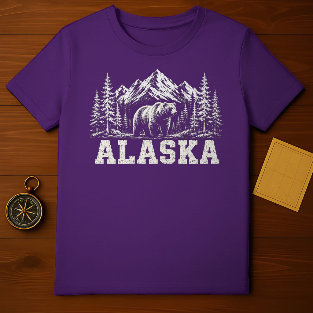 Purple t-shirt with white graphic of bear, trees, and mountains, text "ALASKA".