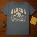 Alaska t-shirt with mountains, trees, sun, and text "The Last Frontier Est. 1959".