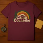 Maroon t-shirt with distressed rainbow and tree graphic reading "Camp Counselor".