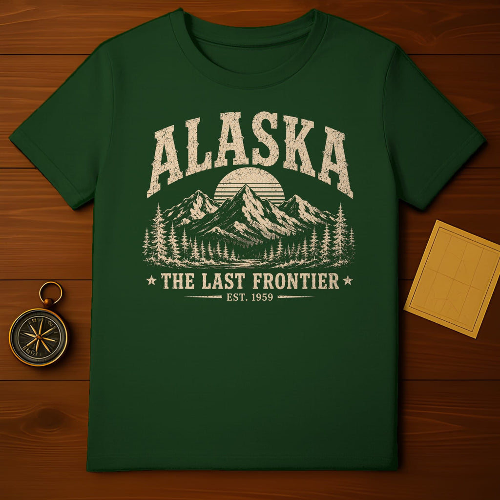 Green t-shirt with "ALASKA," mountains, trees, and "THE LAST FRONTIER EST. 1959" text.