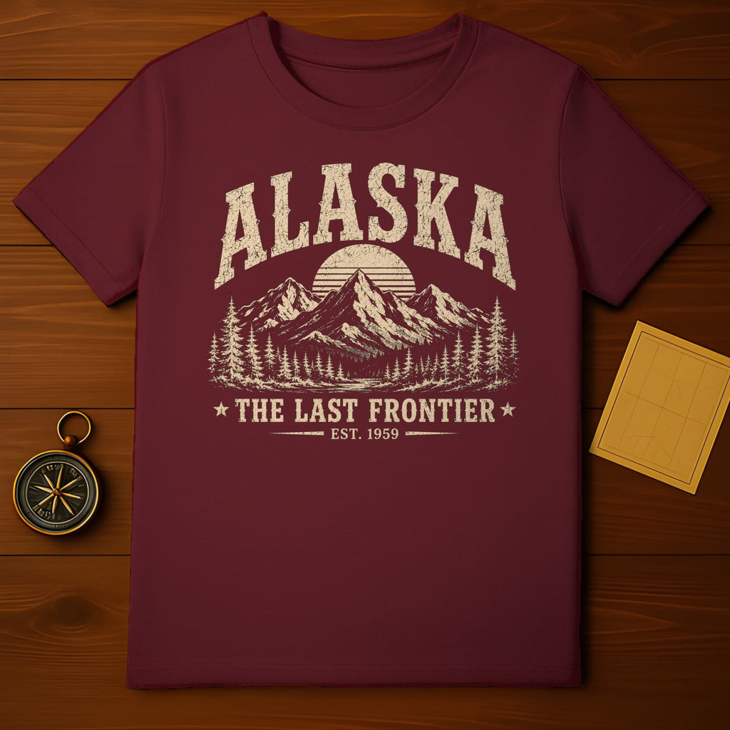 Maroon t-shirt with distressed Alaska mountain graphic and "The Last Frontier Est. 1959" text.