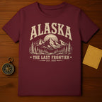 Maroon t-shirt with distressed Alaska mountain graphic and "The Last Frontier Est. 1959" text.