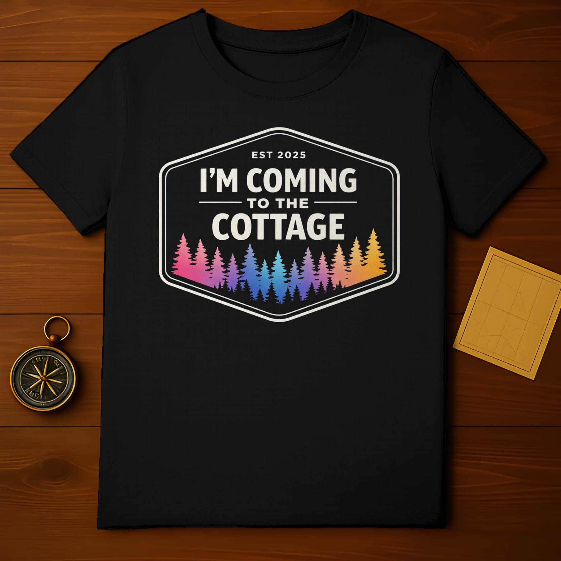 Black t-shirt with "EST 2025 I'M COMING TO THE COTTAGE" and colorful trees.