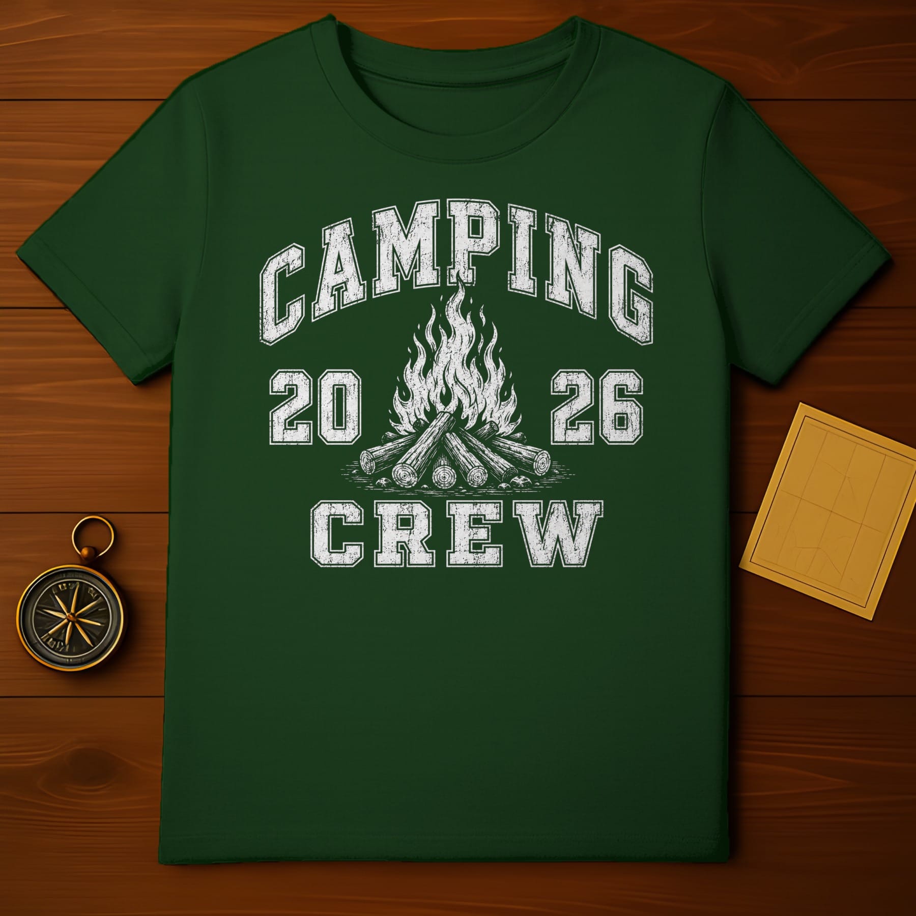 Green t-shirt with white text "CAMPING 20 26 CREW" and campfire graphic.