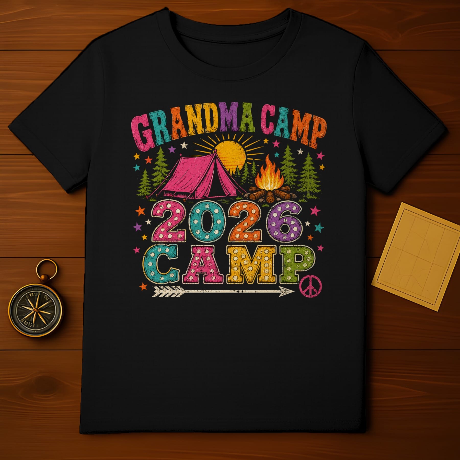 Black t-shirt with "Grandma Camp 2026 Camp" graphic featuring a tent, campfire, and peace sign.