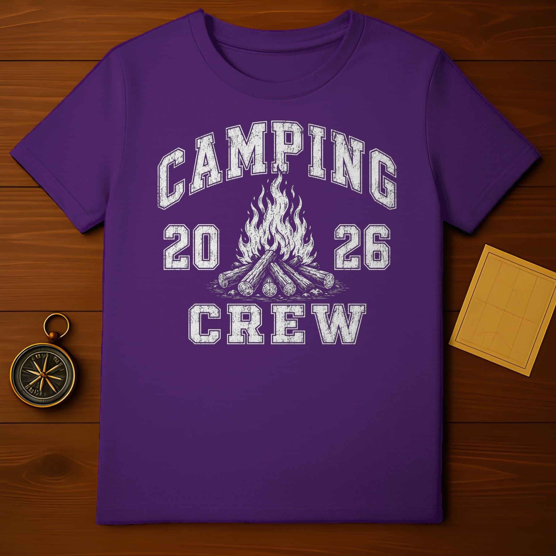 Purple t-shirt with "CAMPING 20 26 CREW" text and campfire graphic.