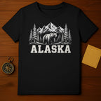 Black t-shirt with a bear, pine trees, and mountains graphic; text "ALASKA".