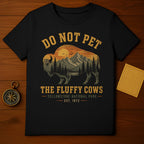 Black t-shirt with graphic of bison, mountains, and text "Do Not Pet The Fluffy Cows Yellowstone National Park".