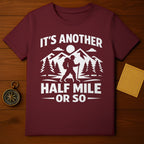 IT'S ANOTHER HALF MILE OR SO Hiker Mountain product type
Hiker shirt
Hiking graphic
Mountain design
Adventure quote
Outdoor exploration
Trail humor
Backpacking gear
Camping trip
Forest landscape
Trees print
Sun scenery
Funny hiker
Sarcastic saying
Travel enthusiast
Wanderlust apparel
Outdoorsy gift
Maroon top
Burgundy clothing
Mountain lover
Exploration tee