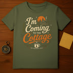 Green t-shirt with "I'm Coming to the Cottage" text and a cabin scene.