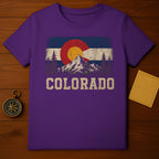 Purple t-shirt with vintage Colorado flag graphic and mountain landscape.