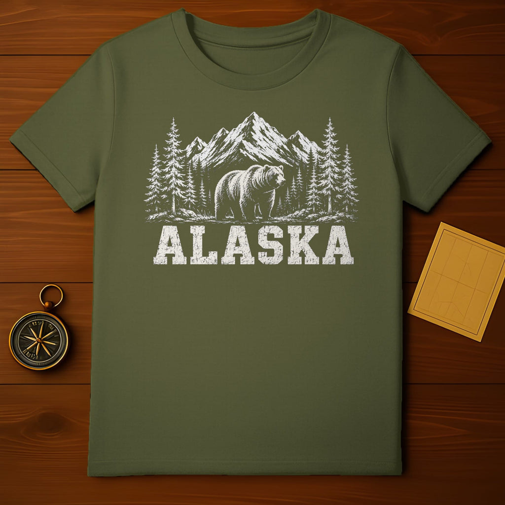Olive green t-shirt with white graphic of a bear, trees, and mountains; text reads ALASKA.