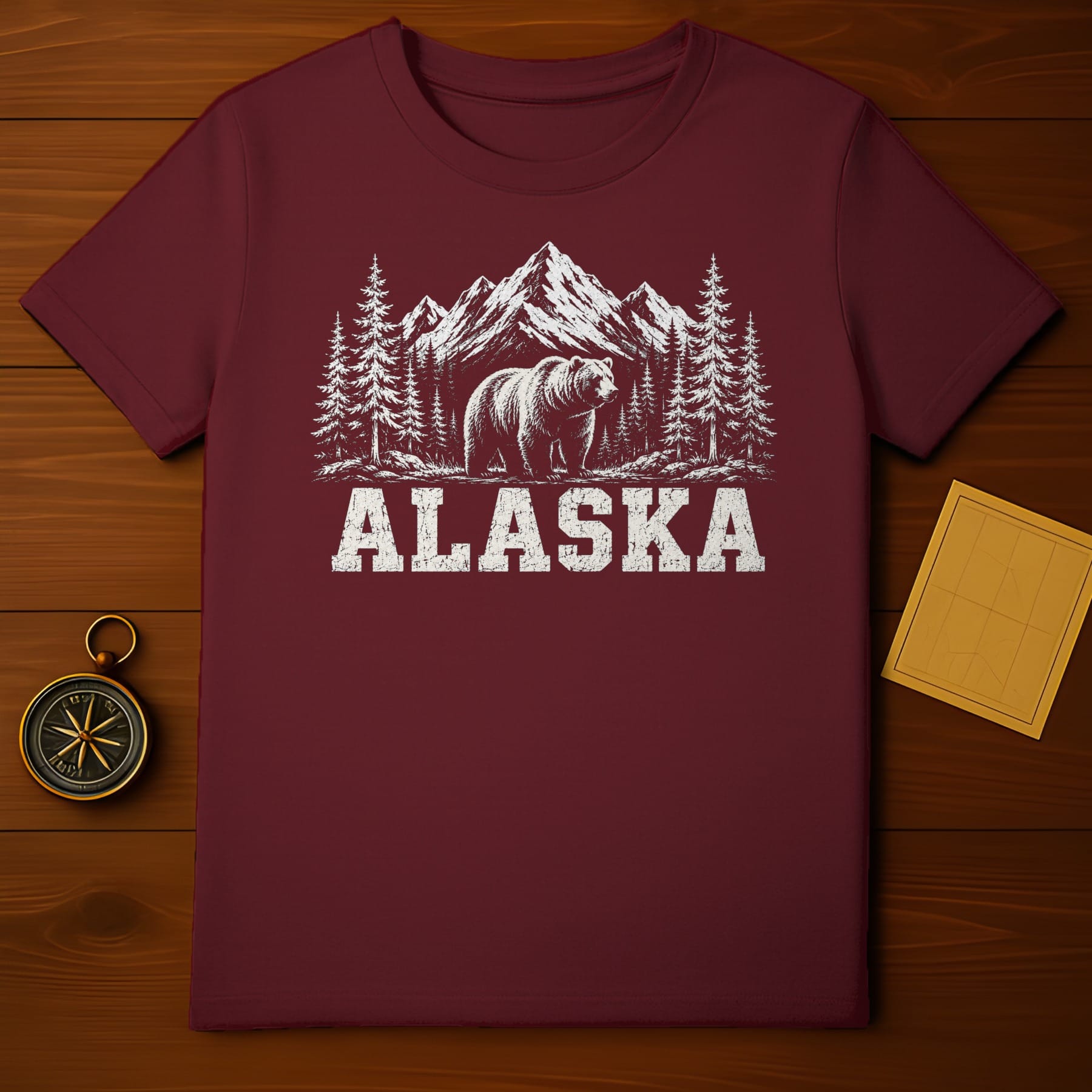 Maroon t-shirt with distressed graphic of bear, pine trees, and mountains.