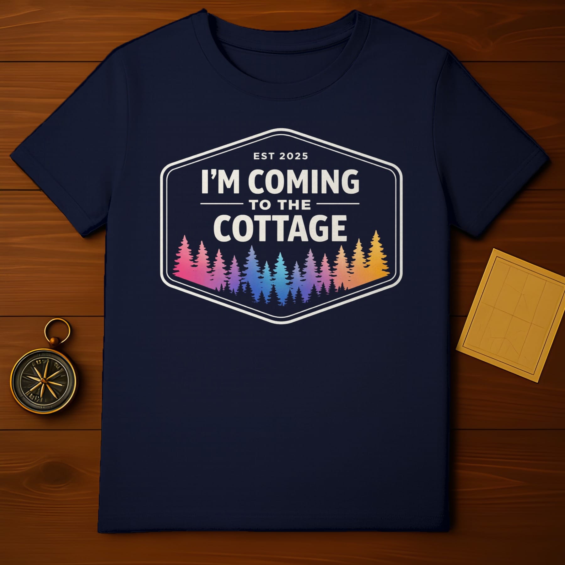 Navy t-shirt with "I'm Coming to the Cottage Est 2025" and colorful trees.