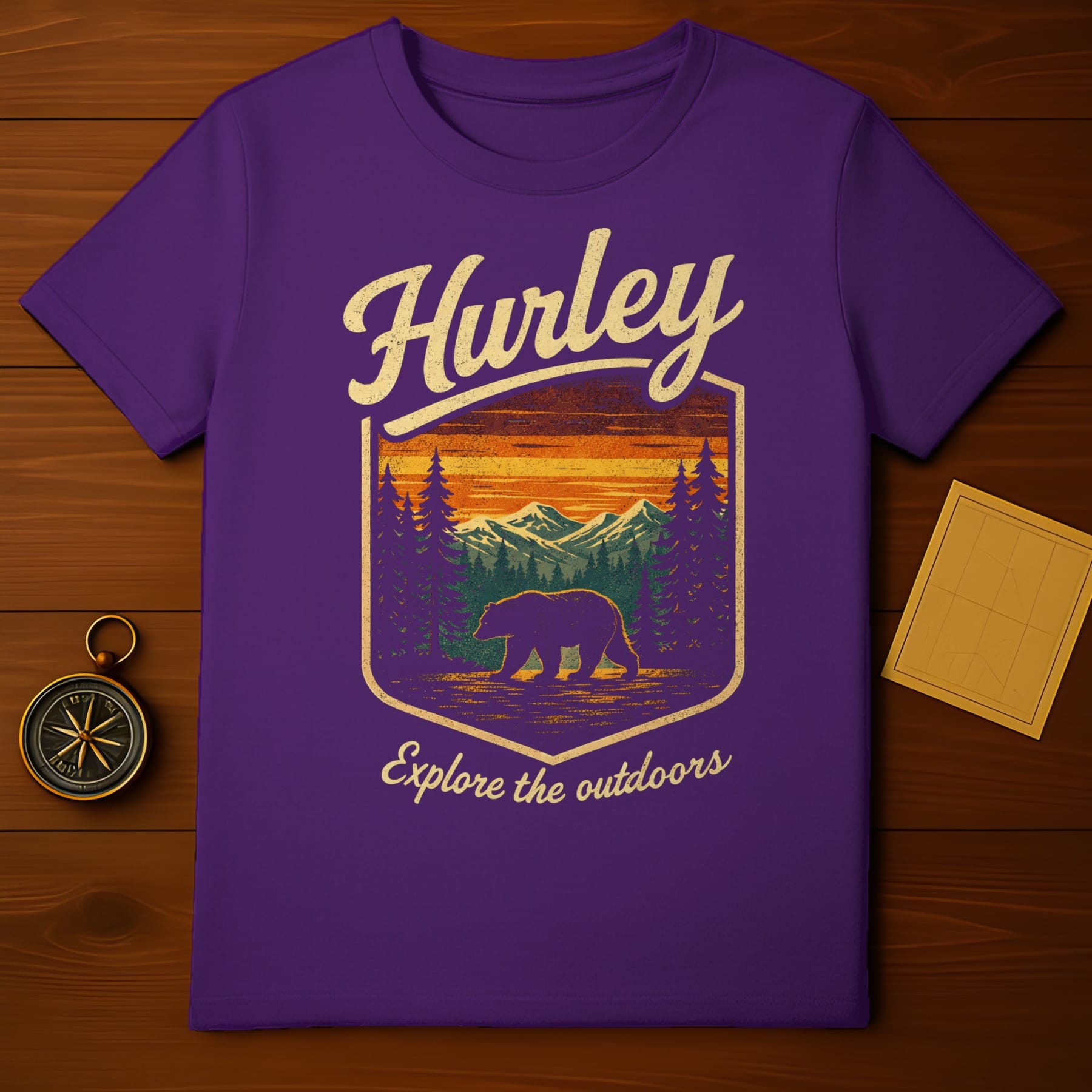 Purple t-shirt with "Hurley Explore the Outdoors" text and bear in forest scene.