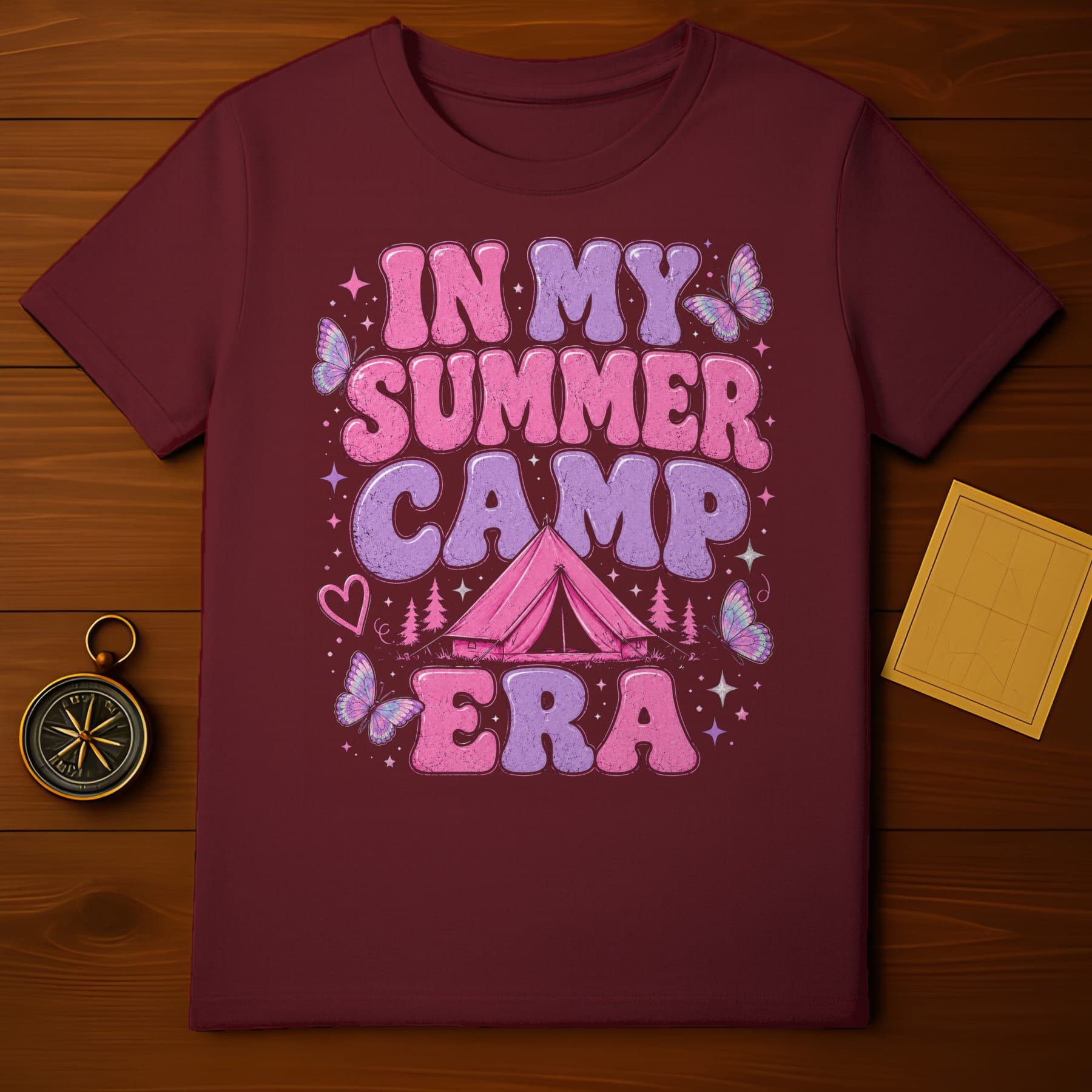 Maroon t-shirt with "In My Summer Camp Era" text and camping graphics.